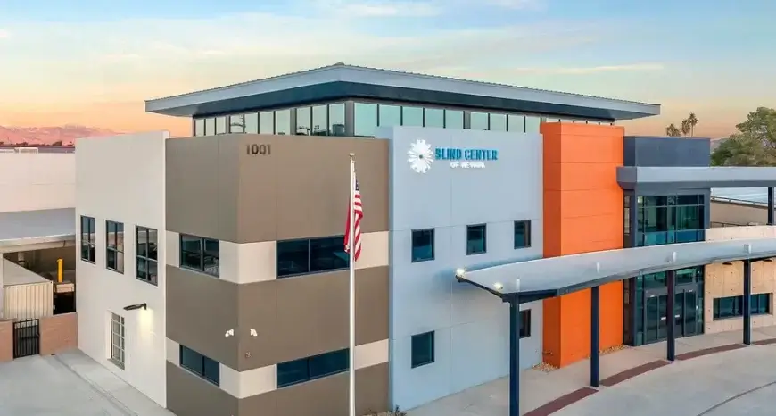 A large, block-colored building that is white, tan, orange and blue with the Blind Center of Nevada sign at the top.